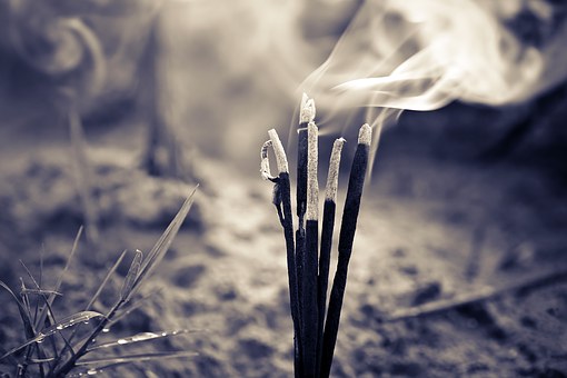 A poem by Tricia McCallum April 2, 2020. .Incense sticks emitting smoke.