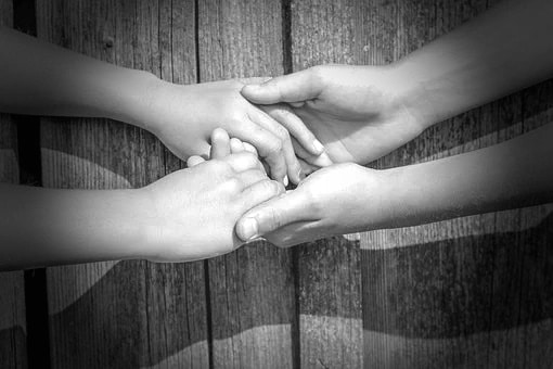 Hands across a table.