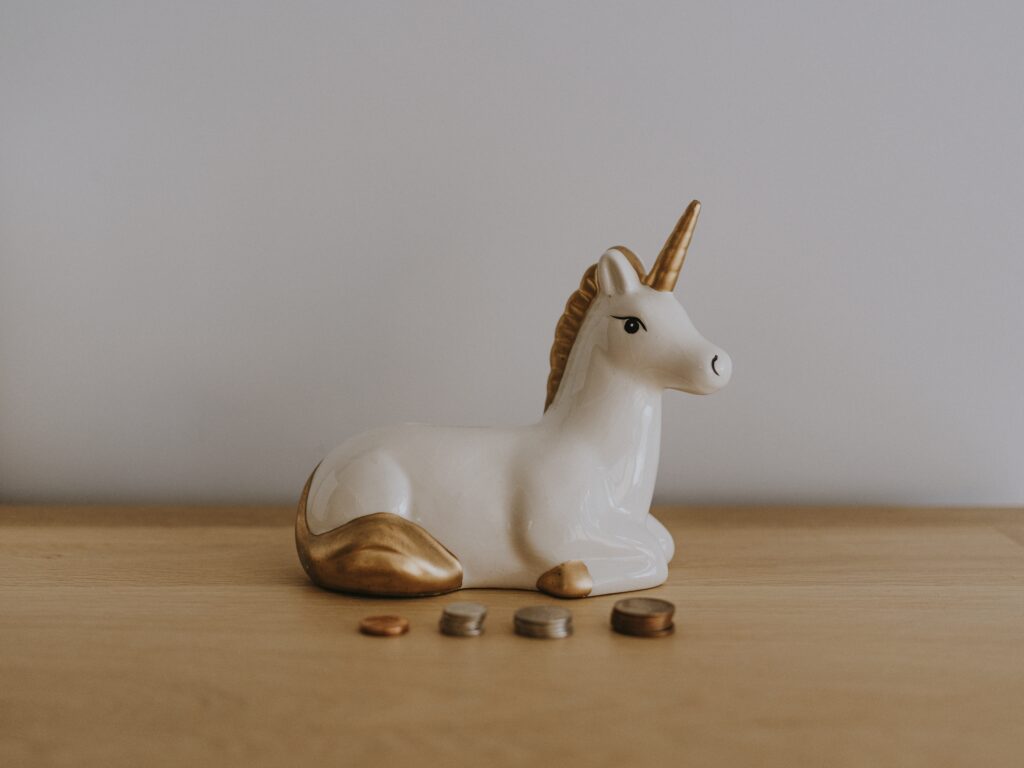 Unicorn money box and coins stacked